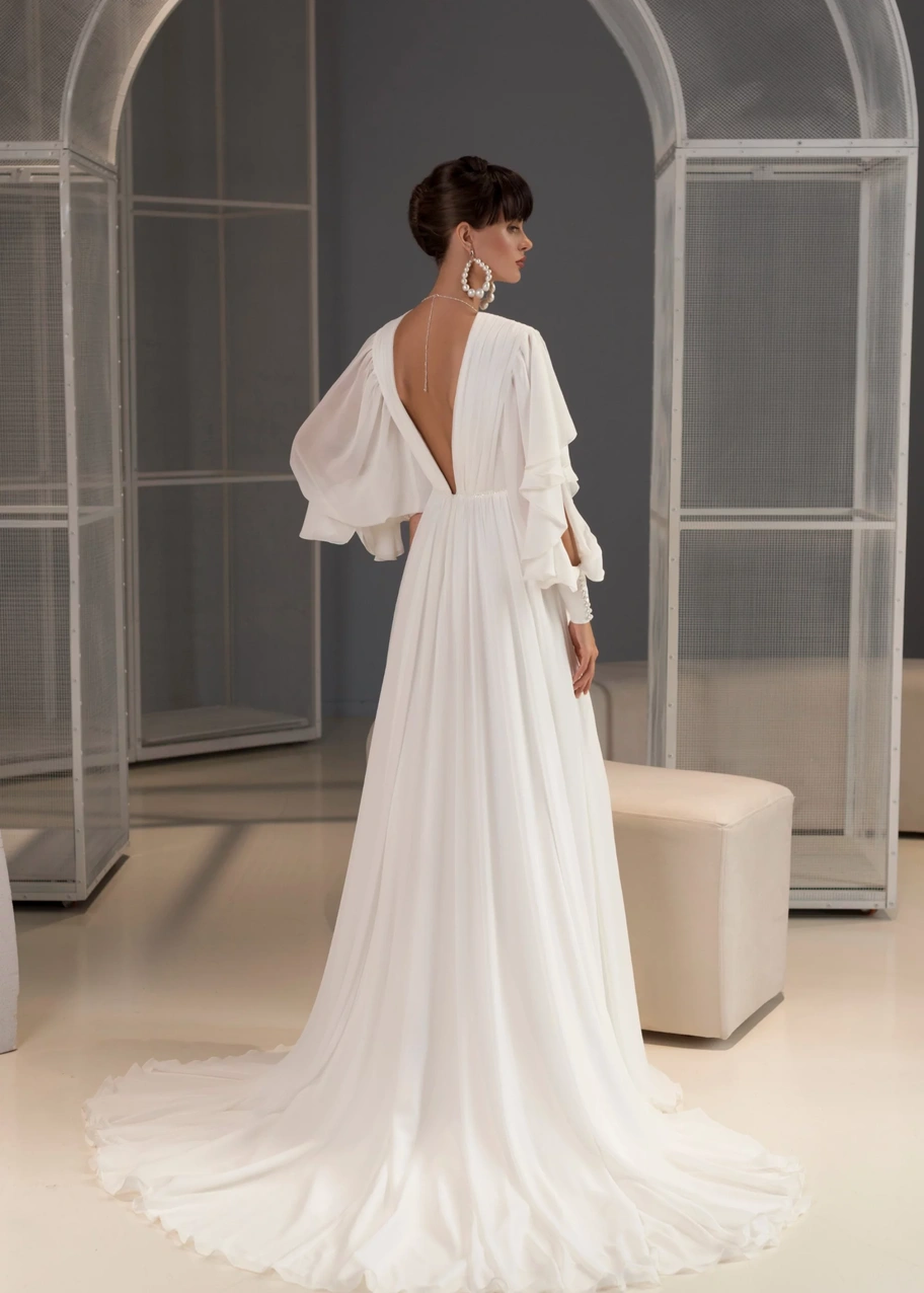 Свадебное платье «Андреа» сзади: открытая спина, длинные рукава с воланами и шлейф.